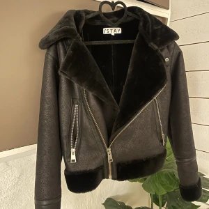 Svart skinn/läder-aktig med fluff - Som i nyskick, köpt på Carlings (tror jag) & originalpriset låg på 800. Skriv privat för fler bilder. Frakt ingår i priset