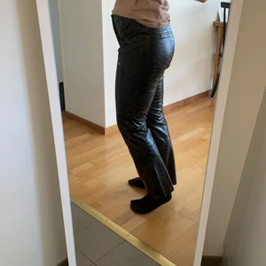 Ormskinnsbyxor - Fraktar eller möts upp i Uppsala! Ormskinnsbyxor i glansigt fakeläder från Carin Wester. Storlek 40 men passar mig som normalt har 36, men är bred över lår och rumpa. Sååå snygga men säljer då jag inte får användning för dem. Hittar inga defekter!