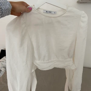 Blus med öppen rygg  - Jättefin vit blus med öppen rygg och snören som man knyter i ryggen 