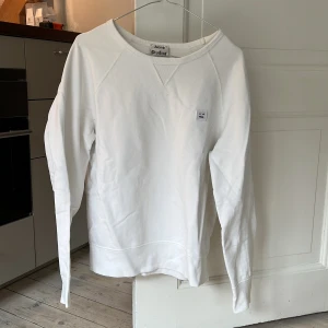 Acne Studios sweatshirt vit - så gott som ny acne studios vit crewneck sweatshirt. relativt oversized vibe med öppen hals, storlek S. 100% bomull, klassiskt plagg!