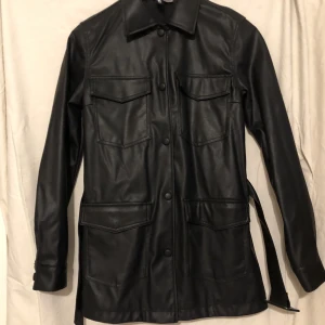 Skinnjacka med bälte - Fejk skinnJacka med bälte och knappar, aldrig använd