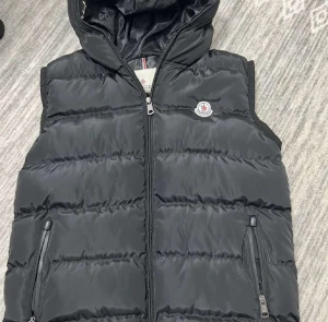 Moncler väst - Säljer min Moncler väst med huva för att jag inte använder den mer den är i perfekt skick har inte använt den ute bara testat inomhus storleken är S säljer den för 500kr