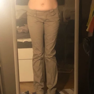 Grå/beiga byxor  - väldigt fina lågmidjade byxor långa i benen (är 175) saknar dock en sån sak att sätta bälte igenom :) bilderna ser ut o vara olika förger men de är en blandning av dem mer åt färgen i andra bilden,,, köparen står för frakten 