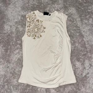 beiget linne - säljer detta linne med coolt tryck. den är även lite ”ihop-sydd” på vänster sida vilket gör linnet extra snyggt. har använts endast ett fåtal gånger och är i extremt bra skick. tröjan är även väldigt stretchig.