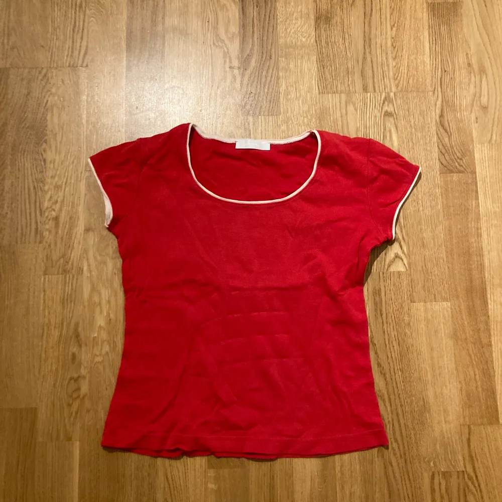 En vanlig röd t-shirt med vita små detaljer. Aldrig använd typ väldigt bra skick.. T-shirts.