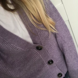 Lila kofta med svart/bruna knappar.  - Det är en lila gosig kofta som jag säljer eftersom det inte är min stil. Jag har aldrig använt den och lappar sitter kvar ( se på andra bilden).