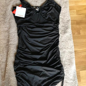 Svart klänning - Svart klänning med scrunch på ena sidan. Strl 38, aldrig använd