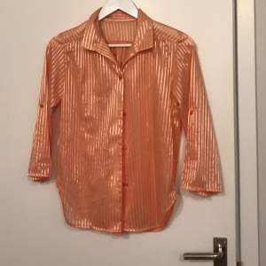 Supervacker orange skimrig skjorta. Storlek står ej men är som en S/M. 