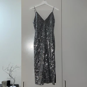 Glittrig klänning ( Nyår ) - Glittrig klänning i silver, perfekt för nyår, mycket fint skick! Använd 1 gång 
