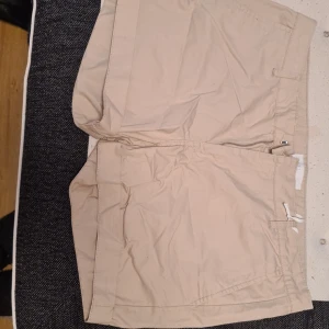 Snygga korta shorts storlek L 44/46 - Ett par snygga korta shorts som är beigea. Inte använda då de är förstora för mig.  Lite skrynkliga för har legat i garderoben
