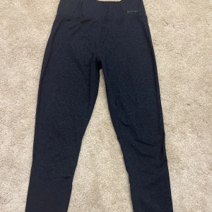 Träningsbyxor  - Träningstights i mörkblå leopardmönster.  Storlek M