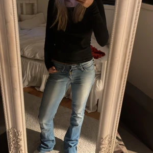 Lågmidjade ljusblå jeans  - Så snygga jeans från Lee. Jeansen har ett hål vid vänstra sidan som man ser på den tredje bilden!!