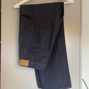 Armani carpenter pants - Riktigt schyssta carpenter pants som sitter perfekt över skorna.   Storlek 48 och passar mig som vanligtvis har 30 i midja. Jag är 180cm och är bra i längd  De är jeansfärgade men har lite tunnare material. Typ som en blandning mellan jeans och chinos