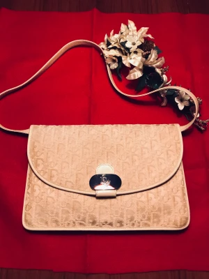 RetroÄkta Christian Dior handväska 70 talet - Äkta Väska Dior 70-talet. Som jag ärvt av min mamma. Vit till färgen inga fläckar eller dylikt. Fungerande lås. Avtagbar axelrem så den kan användasd som kuvertväska också. Ren på insidan. Inte lätt att hitta den i denna färg så fin! Fler bilder! SWISH!