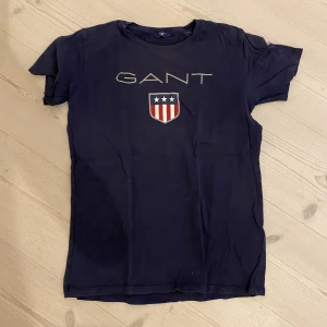GANT  T-Shirt Strl. 146/152 - GANT- T-shirt säljer pågrund av att den har blivit för liten. Skick: 8/10 Kan frakta men då står köparen för frakten.