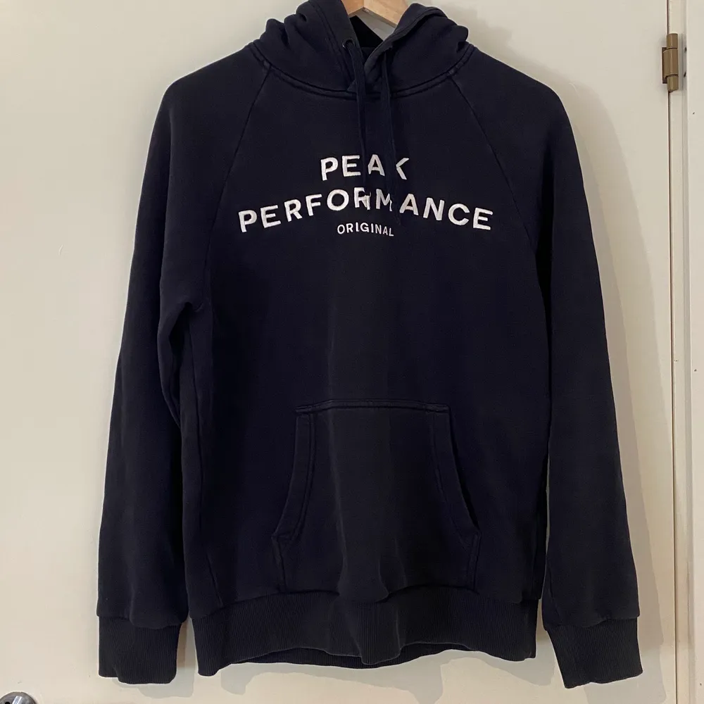 Mörkblå hoodie från PeakPerformance i storlek M (den är dock oversized så passar någon med storlek L också). Den är äkta och knappt använd, säljer då jag aldrig kommer att använda denna igen.. Hoodies.