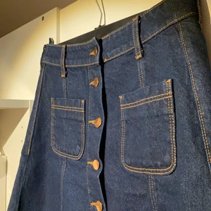 Jeans kjol  -  Jeans kjol med metallknappar. 