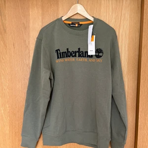 Collagetröja OANVÄND! Grön med orange detaljer - Helt ny collagetröja från Timberland! Skitcool och så snygga färger. Säljes pga köpte två storlekar och missade retur på ena. Nypris 799:-, strl L (oversized!)