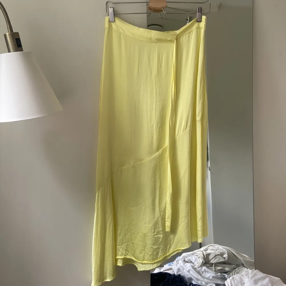 En jätte fin nästan oanvänd gul kjol i siden från Other stories. Den går ner till mitten på smalbenen på mig och är snedskuren längst ner, dragkedja på sidan och ett fint band runt midjan som man knyter för dragkedjan. Köpt för 700kr. Hameet.