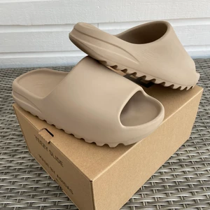 Adidas Yeezy Slides Pure - Säljer dessa Yeezy slides på grund av att jag inte får användning av dom längre. Skicket är bra och inga skador. Dessa slides är i storlek 43 (us9) Köpta från Restocks för 2000kr förra sommaren!