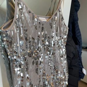 Festlinne från VILA - Helt oanvänd linne från VILA i storlek S. Sjukt fint mönster med paljetterna och sitter fint på. Säljer pga rensar min garderob. Snyggt att ha till fester med ett par low waisted jeans eller en söt kjol!!💕
