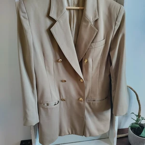 Blazer/kavaj  - Beige blazer/kavaj från Wiman Exclusive i strl 38. Säljes då den är för stor för mig (xs). En äkta 90-talare. Perfekt till våren. Material ren ull. Torrengöring endast. Kommer från djur och rökfritt hem. Frakt betalas av köpare. Om man vill ha annat fraktalternativ så går det att ordna. Betalning sker via Swish och varan skickas så fort betalningen inkommit. Jag ansvarar inte för postens slarv. Bud är bindande. Samfraktar gärna.