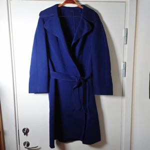 Blå vintagekappa - Marinblå äldre vintagekappa i äkta ull. Den har inga knappar eller liknande utan knyts enbart med bandet i midjan. Diskreta fickor på sidorna. Storleken är som en stor S eller liten M🌱