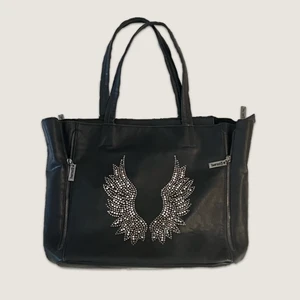 Svart väska med änglavingar - Snyggaste och finaste väskan med rhinestones i mönster av änglavingar 💋 väldigt rymlig med 3 fack inuti! mått 40 x 32cm ♡ kontakta mig privat vid frågor & funderingar 💘 köparen står för frakt!