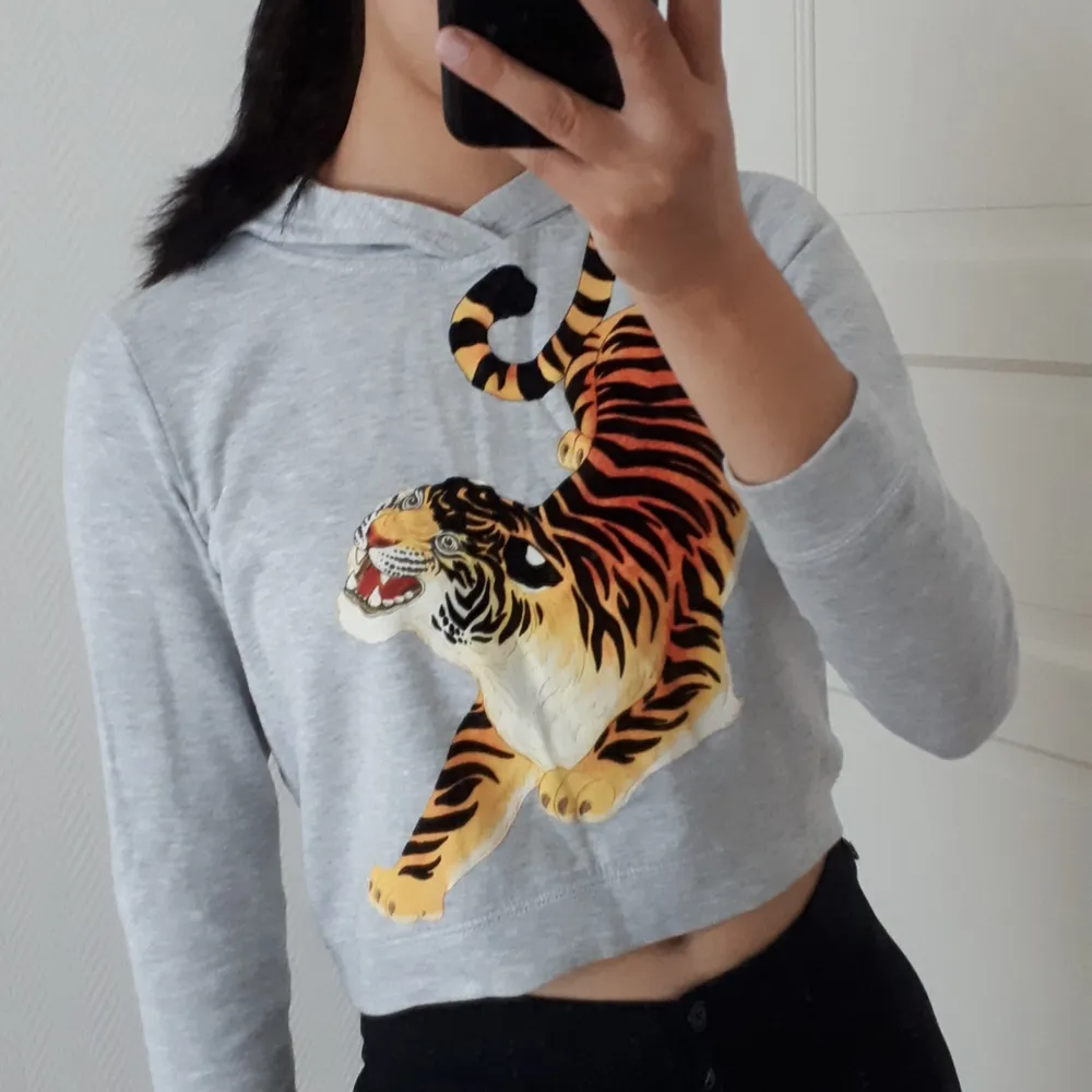 Cool grå hoodie med tigertryck! Den är tyvärr för kort i ärmarna för mig men älskar det coola trycket! Det svarta är dessutom i sammetmaterial. Strl 158/164, passar XS och på S blir passformen som på bilderna :). Hoodies.