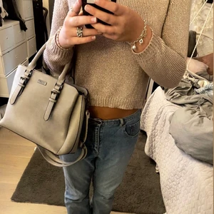 Väska  - Säljer denna dom Donna gråa väska som är perfekt till skolan både långt och kort snöre och handtag. Väskan har flera fack och små fickor. Kom privat vid intresse ! 