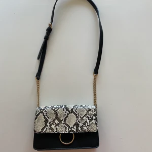 Väska - Säljer en väska ifrån Åhléns med snakeprint på, är i fint skick!
