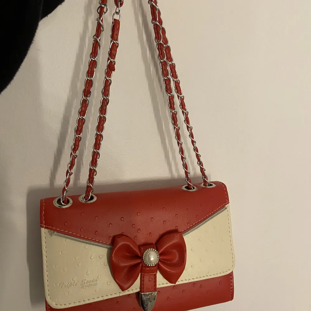 Röd väska med ställbart band, kan både va långt och ställa till två kortare band. . Väskor.