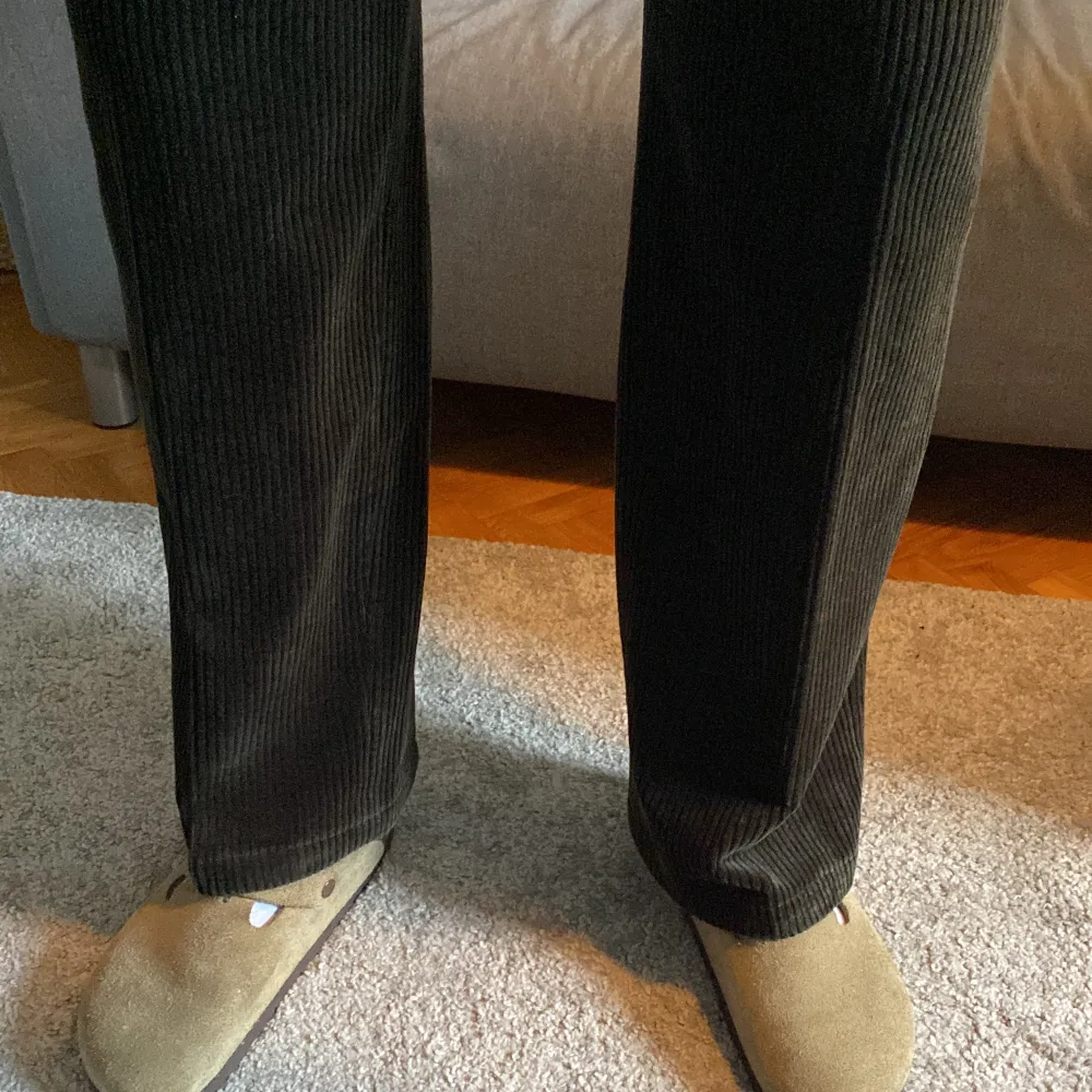 Snygga och breda manchesterbyxor i svart/brun. Ytterbenslängd: 103 cm, Midja: 95 cm, Benöppning: 24 cm. Jeans & Byxor.