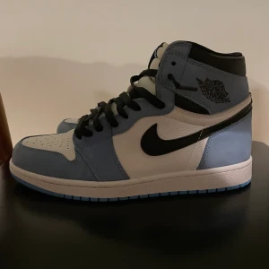 Jordan 1 university blue storlek 46 - Hej, jag säljer nu mina Jordan 1 university blue i storlek 46 Skorna är använda ett fåtal gånger men är i ett väldigt bra skick. Original boxen samt kvitto finns tyvärr inte men dom är köpta på hypestein, Vid frågor skicka gärna ett dm till mig  