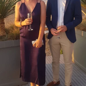 Mörkblå finklänning  - Vacker glansig finklänning i mörkblått. Endast använd 2 ggr, var köpt för bröllop. Har jättefin rygg och slitsar längst ner. Säljer då den blivit för liten för mig. Kostade 800 kronor som ny.