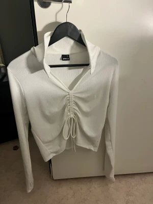 Oanvänd topp - Oanvänd vit topp med snörning i Storlek Xl men skulle säga att den passar M- xl beronde på hur man vill ha den sitta 