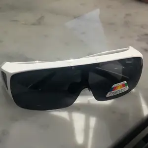 Ett par vita solglasögon med ”Glare blocking” glas. Köparen betalar bara för frakten - 66kr!