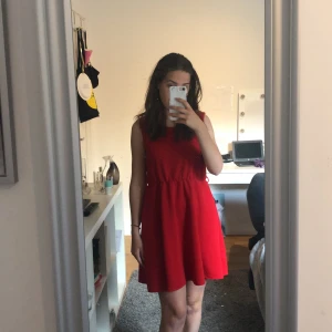 Sommarklänning - Säljer min fina röda sommarklänning. Använd ett fåtal gånger och är i ett bra skick. Ska medfölja ett band men medgick inte när jag köpte den. Först till kvarn. Söker seriösa köpare