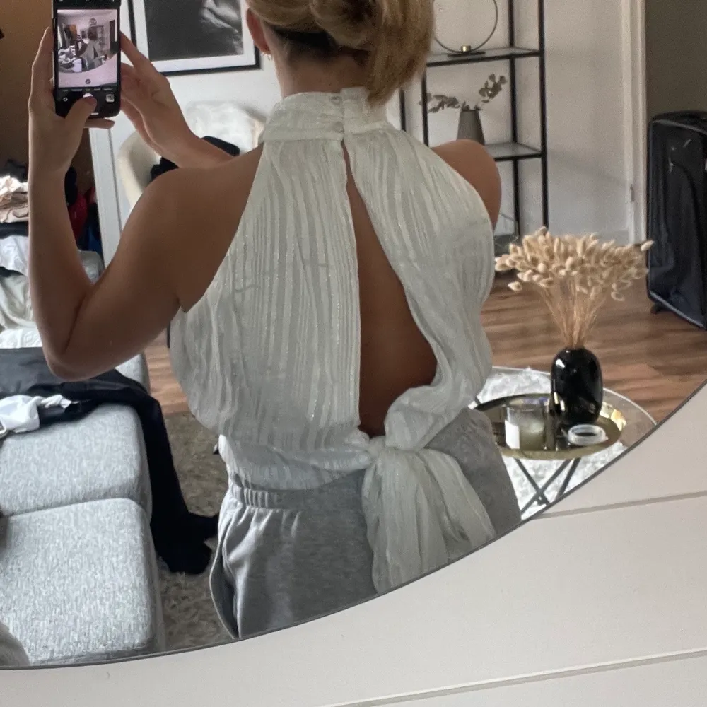 Så fin topp från Asos, helt oanvänd! Glitter i tyget, storlek 38! Öppen rygg med band att knyta till en rosett. Yläosat.