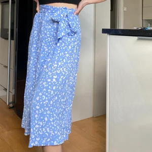 Prickig kjol - Säljer denna ljusblåa kjol med vita ”prickar” och knytband i midjan! Köpt från monki i strl S. Älskar materialet som är så tunt och skönt men ändå inte genomskinlig på nåt sätt. 