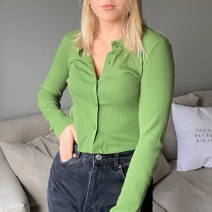 Grön topp - Grön topp med knappar, ribbad med krage.
