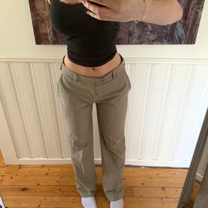 Kostymbyxor - Lågmidjade/mellanmidjade kostymbyxor i en beige brun färg! Är 175 och de är långa på mig så skulle sikta på att de är som en L35! Super fina byxor som går att vika ner för att växla om lite och få se lite tajtare då de bli lite pösiga mellan benen när de inte är ned vikta!💓 säljer för vet inte hur jag ska stajla denna färg ( Dm om du vill ha närmre bild på färgen/materialet)🥰