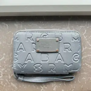 Grå Marc Jacobs plånbok, lite slitage på ”metall brickan” samt på insidan.