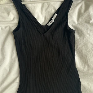 V-ringat linne  - Skitsnyggt v-ringat linne från Na-kd. Storlek S. Använt endast 1 gång!