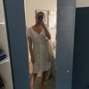 Klänning - Klänning i linne med knäppning fram