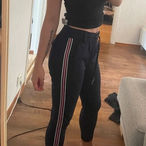 Byxor med rand - Mörkblå byxor med rand på sidan av benen. Storlek XS. 