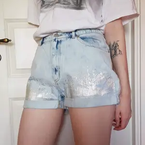 Jeansshorts i ljusblått jeanstyg, med holografiskt tryck. Som nya, endast använda en eller ett par gånger.