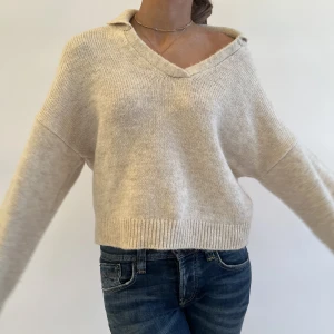 Stickad tröja - Skitsnygg beige stickad tröja som är lite kortare vid magen och har en cool krage!!