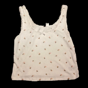 Blommigt linne - Ett vitt linne med spets och små rosa blommer på. Väldigt gulligt om man får säga det själv :) använt fåtal gånger och är i väldigt fint skick. Är i L men funkar mer löst sittande på mig som har S, från h&m. 93 kr inklusive frakt *TRYCK INTE KÖP NU*