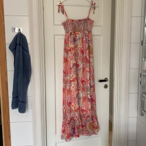 Klänning med paisleymönster - Använd ett fåtal gånger. Jätteskön och luftig med innerkjol! Vet ej vilket märke då det inte står någonstans i klänningen. Den är mer rosa i verkligheten än på bilden